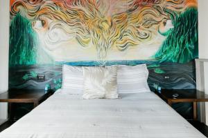 a bedroom with a bed with a mural of a cow at THE PHOENIX HOUSE - EPIC Tiny Home Gem on Volcanic Lava Field! in Kehena