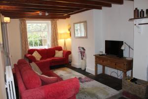 uma sala de estar com dois sofás vermelhos e uma televisão em Avondale em Llangollen