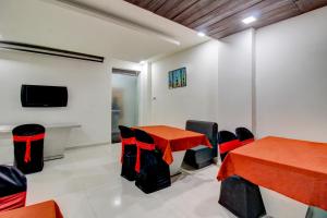 a room with a table and chairs and a tv at Treebo Trend Seven Suites in Nagpur