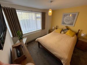 a bedroom with a large bed and a window at Charming Countryside Cottage Ground Floor Apartment in Combeinteignhead Devon in Bishopsteignton