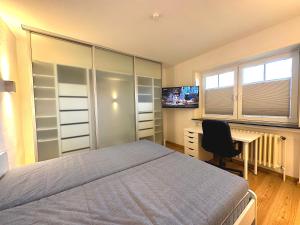 Dormitorio con cama, escritorio y TV en Meer-Lust-Sylt sea cottage lodge en Westerland