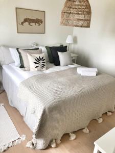 a bedroom with a large bed with white sheets and pillows at Golfinspirerat boende med cyklar, pool och tennisbana in Torekov +25 photos