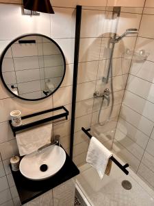 een badkamer met een wastafel en een douche met een spiegel bij Apartament Grodzki in Przemyśl
