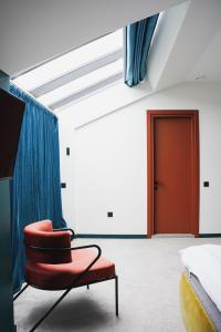 a bedroom with a red chair and a red door at About Sololaki in Tbilisi City