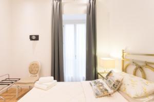sypialnia z łóżkiem, krzesłem i oknem w obiekcie Piazza Venezia Suite and Terrace w Rzymie