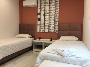 1 dormitorio con 2 camas y una pared con ventana en Πολυτελές οροφοδιαμέρισμα για ονειρικές διακοπές!, en La Canea