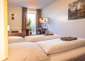 Habitación de hotel con 3 camas y toallas. en Alte Bäckerei, en Parchim