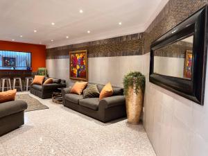 a living room with two couches and a television at Solitaire Guest Apartments in Pretoria