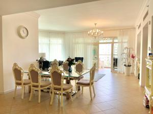 a dining room with a table and chairs and a clock at Luxury, Spacious, Beachfront, 3BD Apartment with private beach access! in Dubai