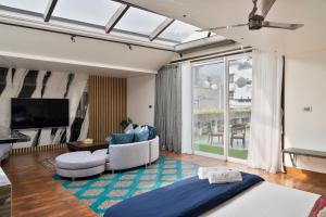 a living room with a bed and a tv at The Moira - Bed and Breakfast in Kolkata