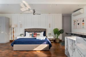 um quarto com uma cama com um cobertor azul em The Moira - Bed and Breakfast em Calcutá