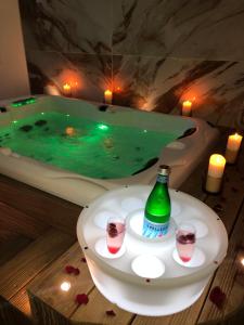 a bath tub with a bottle and two glasses of wine at Studio La Boheme Jacuzzi et Terrasse vu sur Pic Saint Loup in Prades-le-Lez