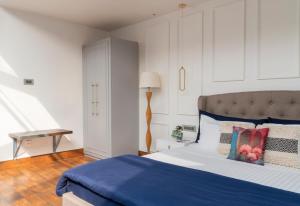 um quarto com uma cama com um edredão azul em The Moira - Bed and Breakfast em Calcutá