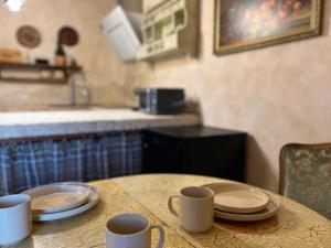 a table with plates and mugs on top of it at Apartment Chalet mit Kamin in Plauen