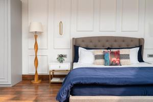 a bedroom with a bed with a blue comforter at The Moira - Bed and Breakfast in Kolkata