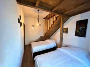 Zimmer im Dachgeschoss mit 2 Betten und einer Treppe in der Unterkunft Apartment Chalet mit Kamin in Plauen