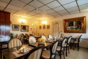 une salle à manger avec des tables et des chaises dans un restaurant dans l'établissement Aerotel Versailles Saint Cyr - L'étape du Silence, à Saint-Cyr-lʼÉcole