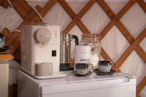 a counter with a coffee maker and cups on it at Cherish Glamping in Askrigg