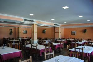 a dining room with tables and chairs with purple table cloth at Hotel Riveiro in Sanxenxo