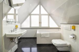 a white bathroom with a sink and a toilet at Black Star Suites in Prague +21 photos
