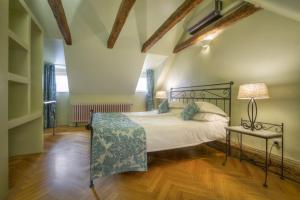 a bedroom with a bed and a lamp on a wooden floor at Black Star Suites in Prague