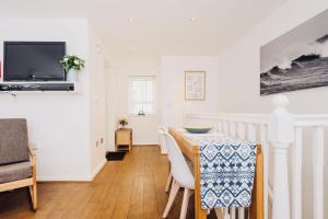 ein Esszimmer mit einem Tisch und einem TV in der Unterkunft Mews House in Brighton & Hove