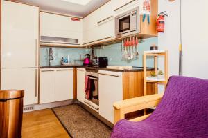 een keuken met een paarse stoel en een magnetron bij Mews House in Brighton & Hove