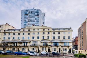 ein großes weißes Gebäude mit davor geparkt in der Unterkunft Mews House in Brighton & Hove