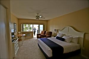 um quarto de hotel com uma cama e uma sala de estar em Shoreline Island Resort - Exclusively Adult em St. Pete Beach