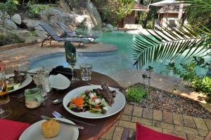 una mesa con platos de comida junto a una piscina en Idube Game Reserve, en Reserva de caza Sabi Sand