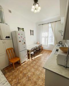 een keuken met een koelkast en een tafel en stoelen bij DAY & NIGHT in Odessa