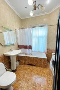een badkamer met een wastafel, een bad en een toilet bij DAY & NIGHT in Odessa