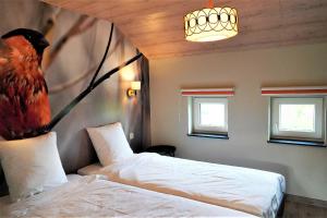 a bedroom with a bed with a bird on a branch at "Petite perle en Haute Ardenne" avec vue sur la vallée, cabine infra-rouge et bain balnéo in Lierneux
