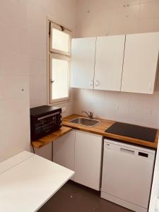 eine kleine Küche mit weißen Schränken und einem Waschbecken in der Unterkunft Sparano Top Class 7 in Bari