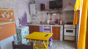 une petite cuisine avec une table et une table jaune dans l'établissement Cuyén Hostel, à Villa María