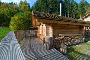 een houten hut met een terras met een dak bij Schwarzwald Romantikhütte *kuschelig *einzigartig in Schenkenzell