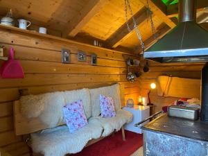 a living room with a couch and a stove at Schwarzwald Romantikhütte *kuschelig *einzigartig in Schenkenzell