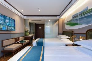 um quarto de hotel com duas camas e uma televisão em Nostalgia Hotel University of Science and Technology Beijing em Pequim