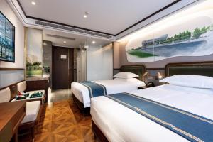 um quarto de hotel com duas camas e uma secretária em Nostalgia Hotel University of Science and Technology Beijing em Pequim