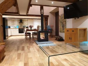 a living room with a fireplace and a table at Galleri hot tub 2 bed ensuite in Blaencelyn