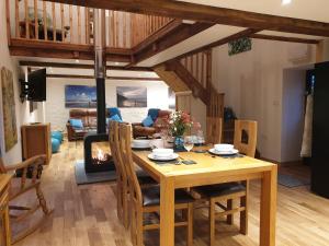 a dining room with a wooden table and chairs at Galleri hot tub 2 bed ensuite in Blaencelyn