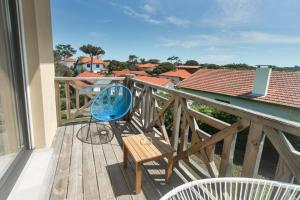 una silla azul en la parte superior de una terraza de madera en Single Fin Hotel & Lodge, en Mimizan-Plage