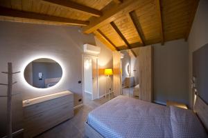 - une chambre avec un lit et un miroir rond dans l'établissement Pieve Del Castello, à Deruta