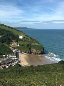 a view of a beach with a house and the ocean at Galleri hot tub 2 bed ensuite in Blaencelyn