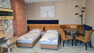 Pokój z 2 łóżkami, stołem i krzesłami w obiekcie Eldom-Noclegi Rogozińska 29E w Wągrowcu