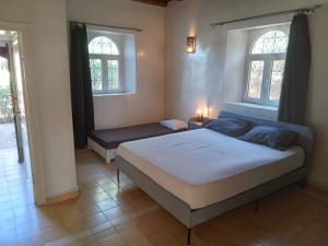 1 dormitorio con 2 camas y 2 ventanas en Villa Mogador en Esauira