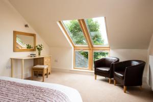 a bedroom with two chairs and a bed and a window at Vesta View in Hexham