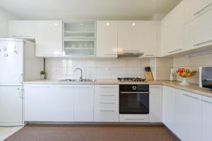 a white kitchen with white cabinets and appliances at Apartmani Blažo in Kali