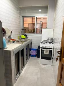 uma cozinha com um fogão e um lavatório em Kolyséhome -Studio, bonamoussadi carrefour eto’o em Douala