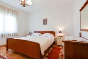 a bedroom with a bed and a dresser and a window at Apartmani Blažo in Kali +37 photos